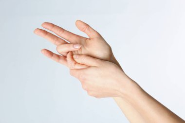 Woman with trigger finger condition on light background, closeup clipart