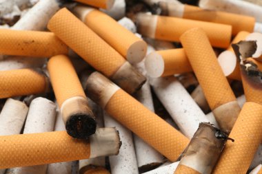Arka plan olarak sigara izmaritleri yığını, yakın görüş