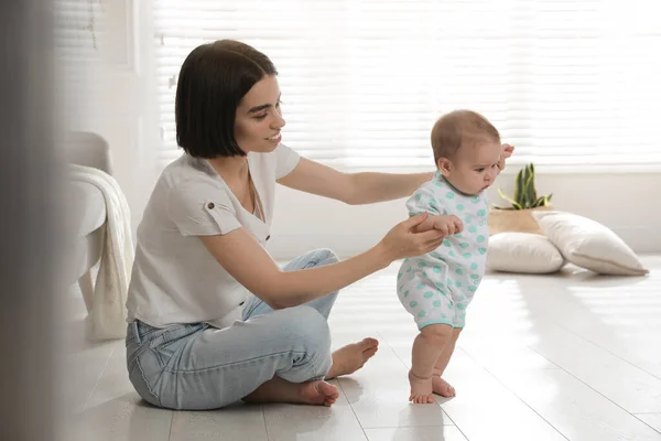 Madre Apoyando Hija Mientras Aprende Caminar Casa —  Fotos de Stock