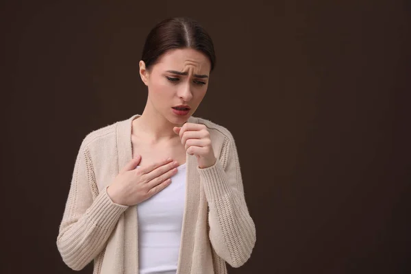 女人咳嗽在褐色的背景 文字的空间 感冒症状 — 图库照片