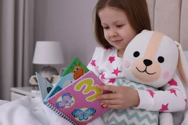 Nettes Kleines Mädchen Mit Spielzeug Lesebuch Bett Hause — Stockfoto