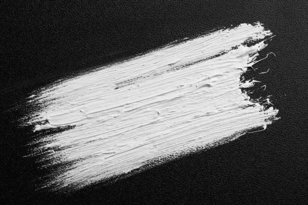 黑色帆布上的白色油画笔画 顶部视图 — 图库照片