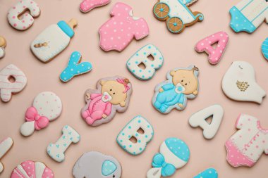 Açık pembe arka planda bebek partisi kurabiyeleri, düz yatış