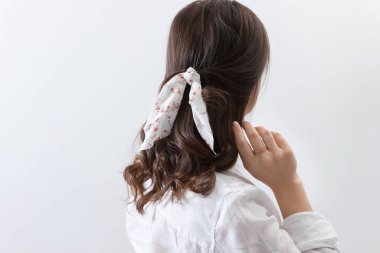 Hafif arka planda şık bandanalı genç bir kadın.