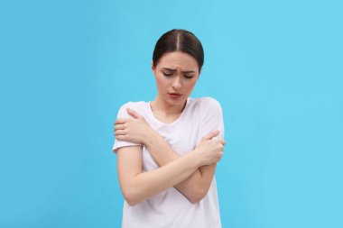 Açık mavi arka planda ateşi olan bir kadın. Soğuk belirtileri