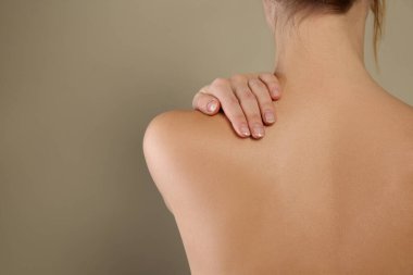 Bej arka planda kusursuz pürüzsüz bir cilde sahip bir kadın, yakın plan. Güzellik ve vücut bakımı