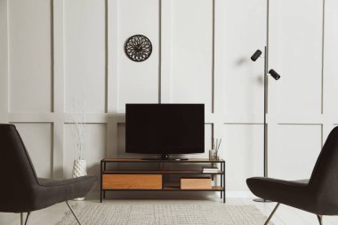 Modern TV standı ve koltukları olan zarif bir oda.