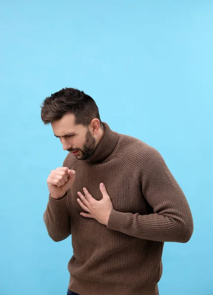 男人在浅蓝色的背景上咳嗽 感冒症状 — 图库照片