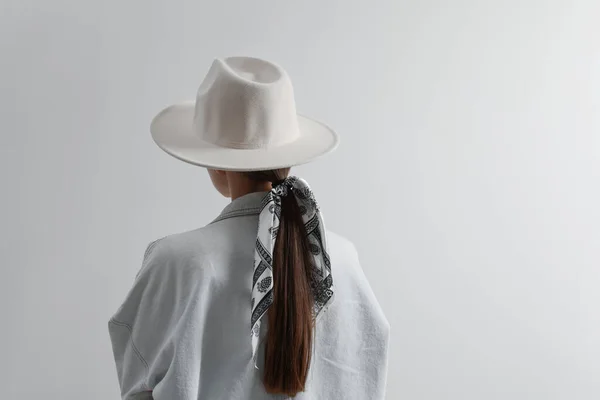 光を背景に帽子とスタイリッシュなバンダナを持つ若い女性 バックビュー テキストのスペース — ストック写真