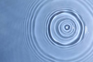 Mavi zemin üzerinde daireler olan suyun yakın görüntüsü