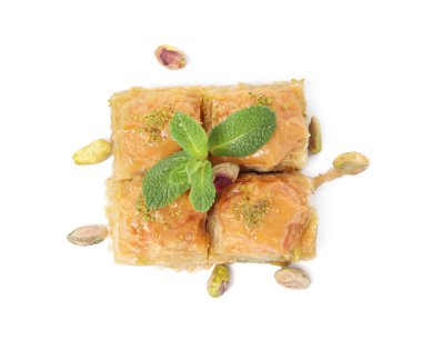 Fıstıklı enfes baklava, beyaz arka planda naneli ve dağınık fındıklı.