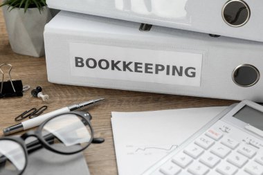 Masasında klasörler ve belgeler olan muhasebecinin çalışma yeri