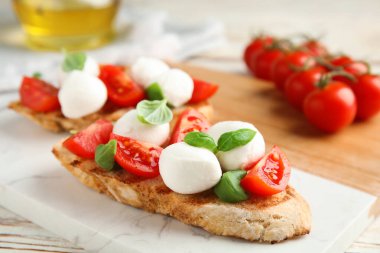 İçinde mozzarella, taze domates ve fesleğen olan lezzetli bir sandviç.