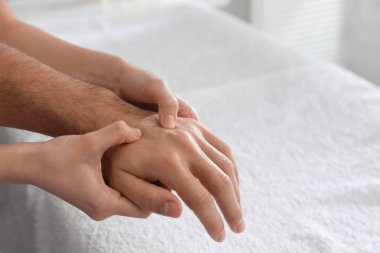 Sağlık merkezinde el masajı yaptıran adam, yakın plan.