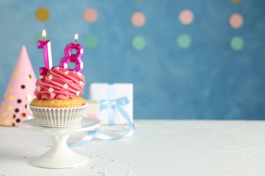 Reşit olma partisi - 18. yaş günü. Beyaz masa üzerinde numara şekilli mumları olan lezzetli kek, metin için boşluk