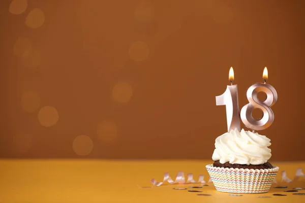 年齢層のパーティー 18歳の誕生日 オレンジの背景に数形のキャンドルを持つおいしいカップケーキ テキストのためのスペース — ストック写真