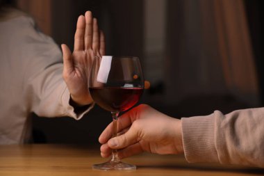 Kapalı mekanda kırmızı şarap içmeyi reddeden kadın, yakın plan. Alkol bağımlılığı tedavisi