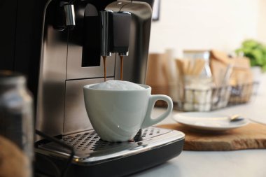 Modern kahve makinesi mutfakta cappuccino yapıyor, metin için yer var.