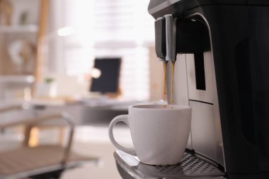 Modern espresso makinesi ofiste fincana kahve dolduruyor. Metin için boşluk