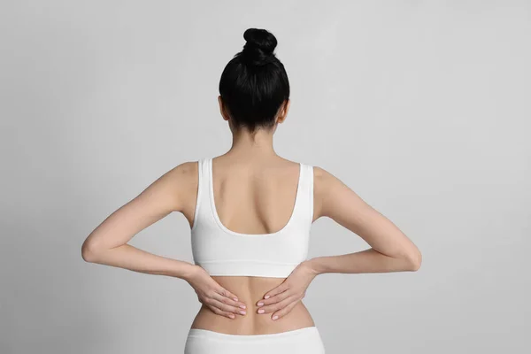 Mujer Que Sufre Dolor Espalda Sobre Fondo Claro —  Fotos de Stock