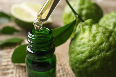 Bergamot 'un temel yağı pipetten masaya damlıyor, yakın plan.