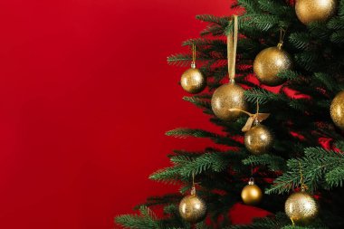 Kırmızı arka planda güzel dekore edilmiş Noel ağacı, yakın plan. Metin için boşluk