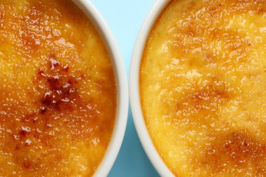 Açık mavi zemin üzerinde ramekins lezzetli creme brulee, düz yatıyordu