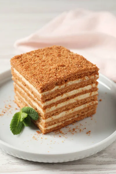 Scheibe Köstlichen Geschichteten Honigkuchen Mit Minze Auf Weißem Holztisch Serviert — Stockfoto
