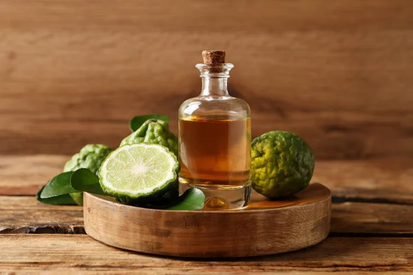 Ahşap masada cam bir şişe bergamot yağı.