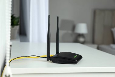 Beyaz masadaki modern Wi-Fi yönlendirici.