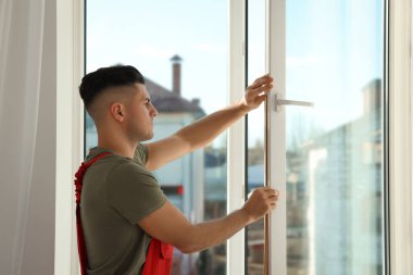 İşçi içerideki pencereye lastik şerit takıyor