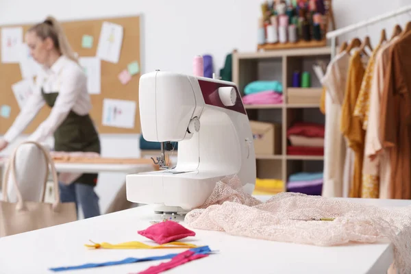 アトリエで働くドレスメーカーは ミシンやアクセサリー付きのテーブルに焦点を当て — ストック写真
