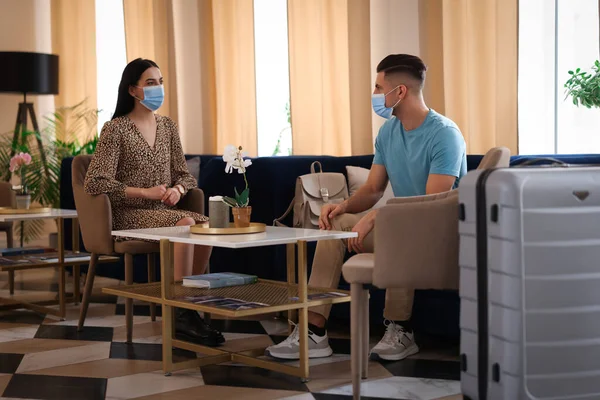 Casal Com Máscaras Médicas Tendo Conversa Enquanto Espera Sala Hotel — Fotografia de Stock