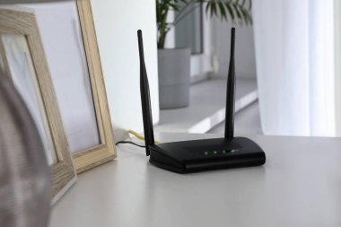 Beyaz masadaki modern Wi-Fi yönlendirici.