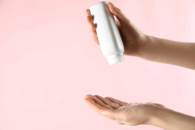 Pembe arka plana toz tozu süren bir kadın, yakın plan. Metin için boşluk