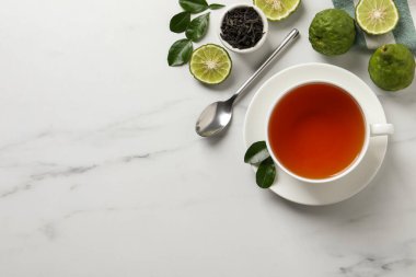 Lezzetli bergamot çayı, kuru yapraklar ve beyaz masada taze meyveler. Metin için boşluk