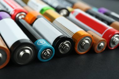 Siyah arkaplanda birçok farklı pil, yakın plan