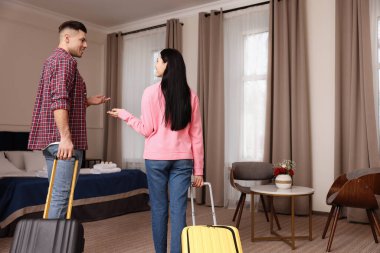 Bavulları olan mutlu çift otel odasına giriyor.