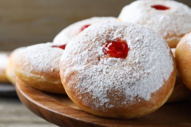 Ahşap pasta standında reçelli lezzetli çörekler ve pudra şekeri, yakın plan.