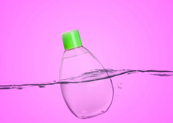 Eine Flasche Babyöl Schwimmt Wasser Vor Rosa Hintergrund — Stockfoto