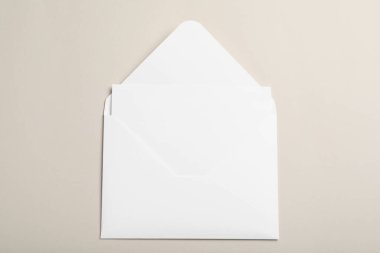 Beyaz kağıt zarf. Bej arkaplan üzerinde boş kart, üst görünüm.