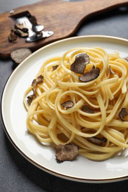 Gri masada yer mantarlı lezzetli fettuccine, yakın plan.