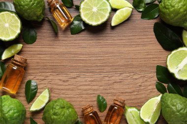 Çerçevesi bergamot esaslı cam şişeler ve ahşap masa üzerinde taze meyveler, düz uzanmış. Metin için boşluk