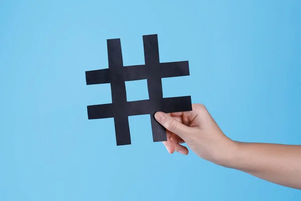 Woman Holding Black Paper Cutout Symbol Hashtag Turquoise Background Closeup — Stock Photo, Image
