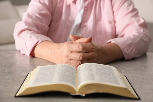 Ώριμη Γυναίκα Βίβλο Προσεύχεται Γκρι Τραπέζι Εσωτερικούς Χώρους Closeup — Φωτογραφία Αρχείου