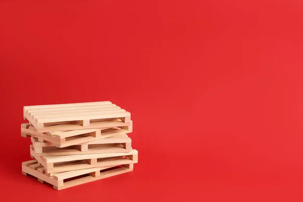 Stack Träpallar Röd Bakgrund Utrymme För Text — Stockfoto