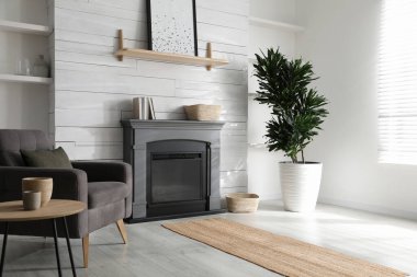 Rahat koltuğu ve modern elektrikli şöminesi olan rahat bir oturma odası.