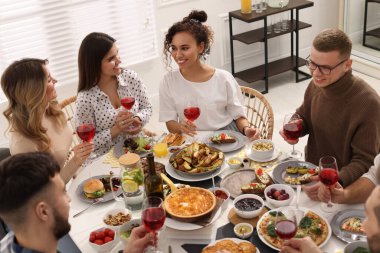 Bir grup insan kapalı bir masada brunch yapıyor.