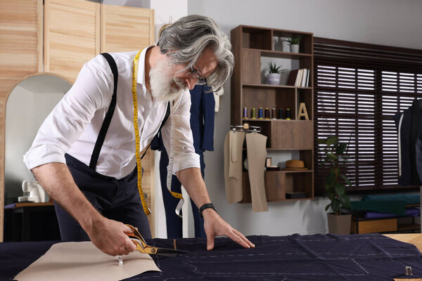 Профессиональный пошив тканей, следуя мел швейный шаблон за столом в мастерской, пространство для текста