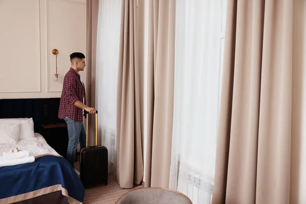 Όμορφος Άντρας Βαλίτσα Κοντά Στο Παράθυρο Στο Δωμάτιο Του Ξενοδοχείου — Φωτογραφία Αρχείου